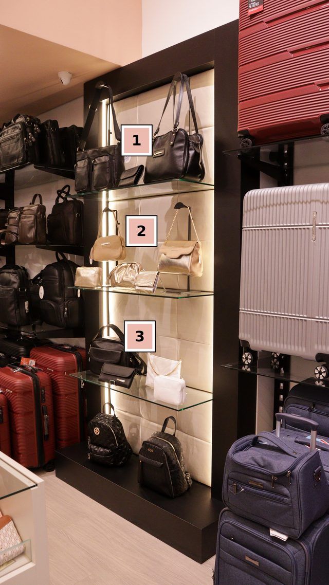 Nicho da loja Edubolsas com bolsas pretas, douradas e brancas, cada uma com a carteira da mesma cor na frente